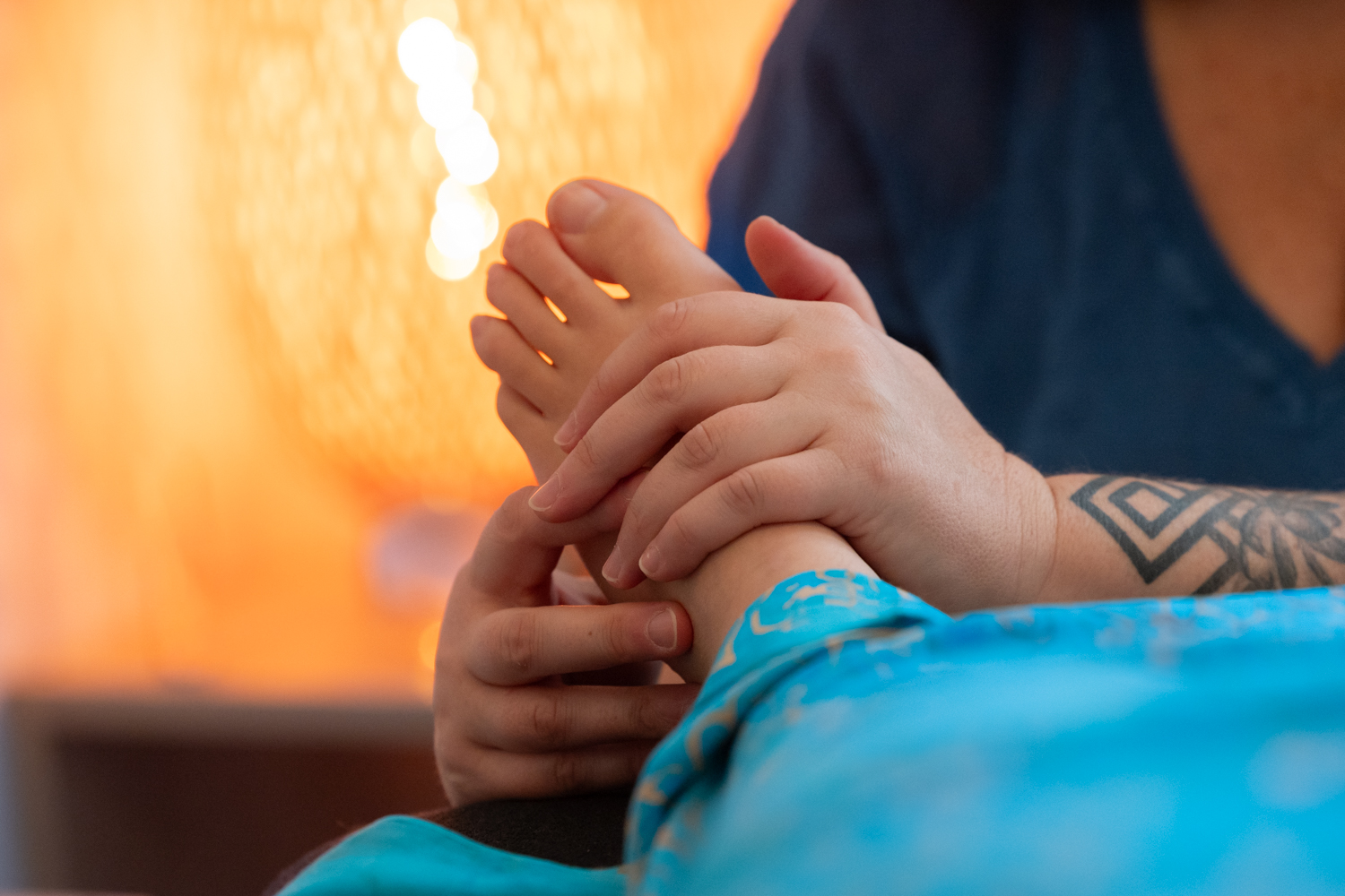 Julie pratiquant la réflexologie plantaire sur un pied — apprendre par le toucher pendant la formation